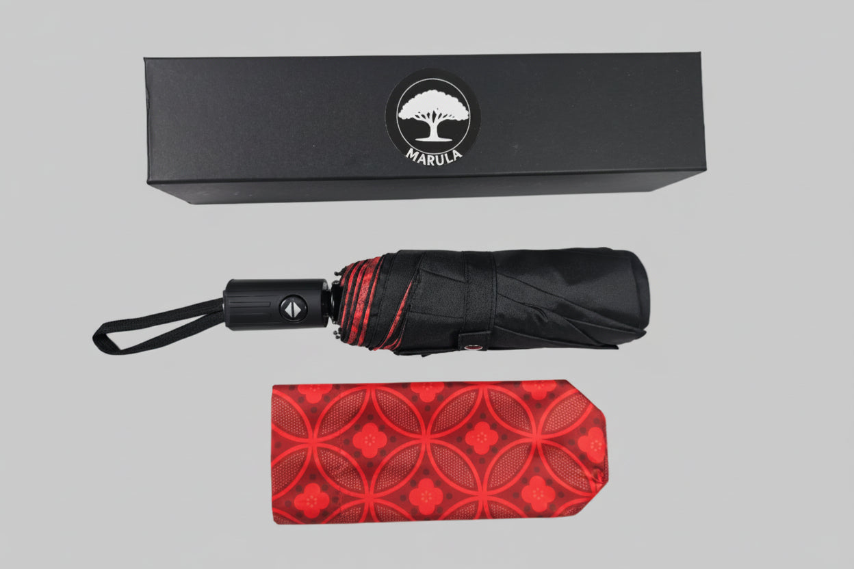 Black umbrella with red patterned cover and black box featuring a logo on a white background