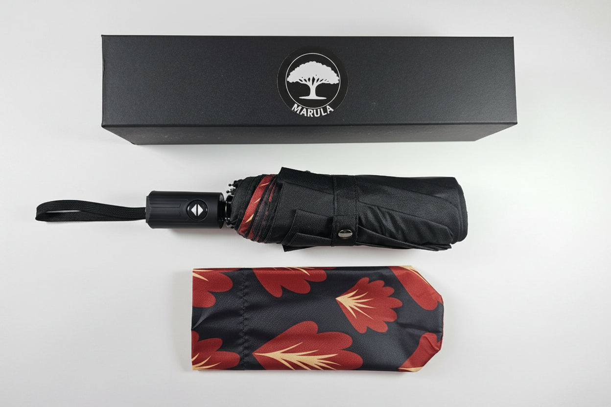 Black umbrella with floral patterned cover and Maruca brand box on a white background