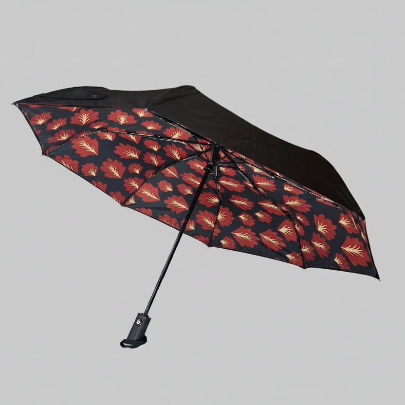 Black umbrella with leaf pattern on a white background